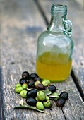 Oliven und eine Flasche Olivenöl