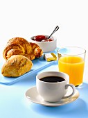 Klassisches Frühstück mit Brötchen, Croissant, Butter, Marmelade, Kaffee und Saft