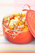 Casserole dish of rabbit legs with tomato sauce and green olives