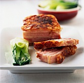 Thick piece of grilled bacon with pak-choi