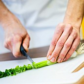 Cutting a spring onion into thin slices