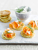Mini blinis with smoked salmon and parmesan flakes