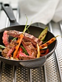 Sliced veal steak with young vegetables and mustard seeds