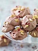 Small chocolate meringues with pine nuts and pink peppercorns