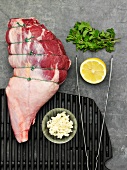 Raw stringed leg of lamb and ingredients