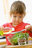 Young girl preparing a french dressing for the salad