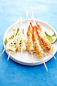 Shrimp brochettes coated with sesame seeds and grilled fennel brochettes