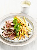 Sliced roast beef with celery, carrots, squash seeds and herbs