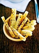 Flaky pastry cheese straws with golden and black sesame seeds