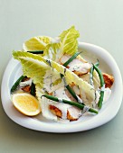 A salad with breaded chicken breast, green beans and cream