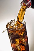 Coca Cola in ein Glas mit Eiswürfeln einschenken