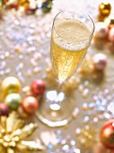 Ein Glas Champagner auf weihnachtlichem Tisch