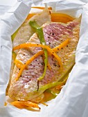 Red mullet with carrots and spring onions cooked in wax paper