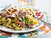 Plate of leg of lamb with flageolet beans and carrots