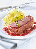 Thick piece of doe with cranberries and mashed potatoes