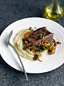 Thick ostrich fillet with mashed potatos and wild mushrooms