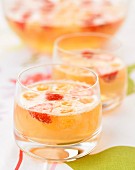 Cocktail mit Champagner, Pfirsichcreme und Erdbeeren