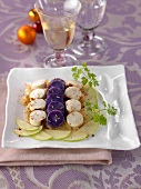 Sliced white sausages and purple potatoes,onion jam and green apples
