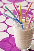 Glass of milk with colored straws