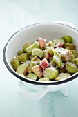 Chopped rhubarb in a colander sprinkled in sugar