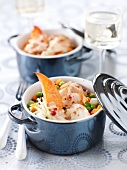 Small casserole dishes of lobster and spring vegetables with a ginger emulsion