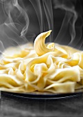 Curl of butter on a plate of steaming pasta