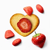 Herzförmiges Plätzchen mit frischen Erdbeeren und Erdbeerkonfekt