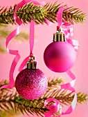 Pinkfarbene Christbaumkugeln hängen am Weihnachtsbaum