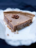A slice of shortcrust tart with chestnut cream and walnuts
