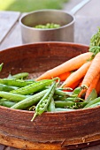 Spring peas and carrots in a sieve