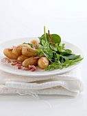 Baked new potatoes with diced bacon and mesclun