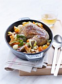 Leg of guinea-fowl with vegetables and mushrooms served in a casserole dish