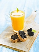 Black fermented garlic paste and a glass of orange juice