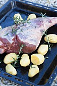 Leg of lamb with potatoes and rosemary before roasting