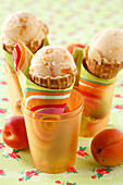 Drei Eistüten mit Aprikosen-Mandeldrink-Eis in Becher