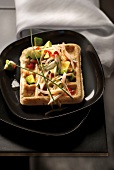 Waffle topped with shallots, avocados and tomatoes