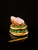 Layered blinis,cabbage and sliced duckling with orange coulis on a black background