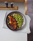 Caramelized veal rib roast with peas and bacon