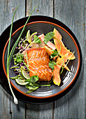 Piece of grilled salmon with exotic sprout and papaya salad