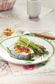 Hake with crushed tomatoes and olives, bundle of steamed green asparagus