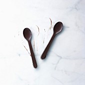 Zwei Löffel aus Schokolade auf Marmor