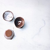 Geschmolzene Schokolade in Papierförmchen zum Formen von Schokoladenschälchen
