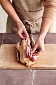 Barding a poultry: covering the poultry with strips of bacon