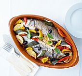 Oven-baked bass with summer vegetables,fennel and lemon