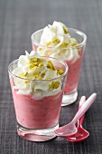 Raspberry mousse with whipped cream and pistachios