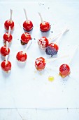 Cherry tomatoes coated in citronella-flavored caramel with poppy and sesame seeds