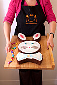 Woman presents chocolate Easter bunny cake