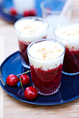 Stewed cherries with whipped cream and almonds