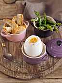 Boiled goose egg, green asparagus and bread fingers