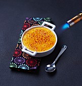 Crème brûlée mit einem Bunsenbrenner karamellisieren